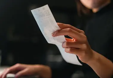 A person holding a piece of paper in their hand.