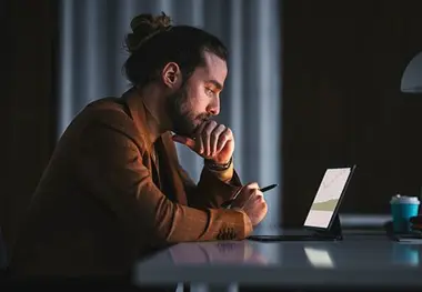 A man sitting at a table with his laptop.